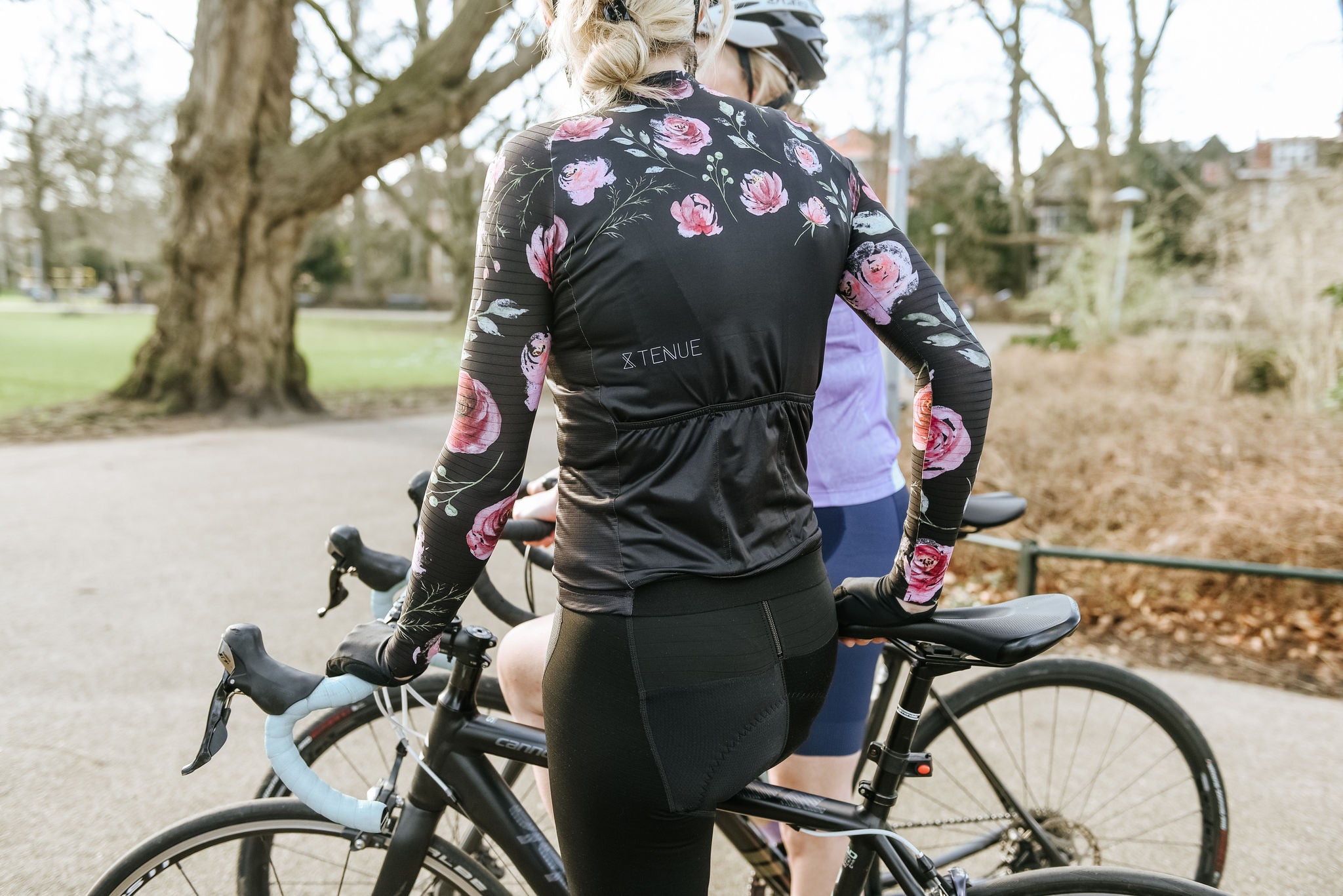 De achterkant van het wielershirt lange mouwen voor vrouwen in de kleur zwart met roosjes.