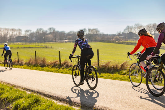 Groep vrouwen die langs een mooi landschap wielrennen