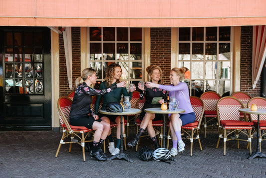 4 vrouwen die een tussenstop hebben bij een café, tijdens het wielrennen.